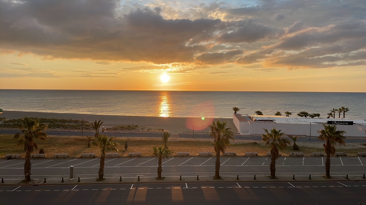 Photo d'un coucher de soleil sur la plage vue du balcon